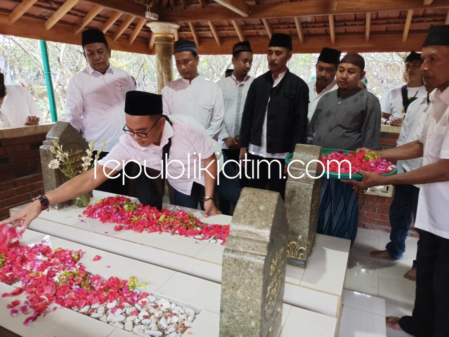 TABUR BUNGAH - Kades Sumorame, Kecamatan Candi, Sidoarjo, Rochmanu dan Ketua Pelaksana Ruwah Desa Sumorame, Irwan Susanto menabur bunga di atas makam Mbah Bagyo bersama istrinya yang baru direhab akhir Tahun 2022 kemarin, Kamis (02/03/2023) sore.