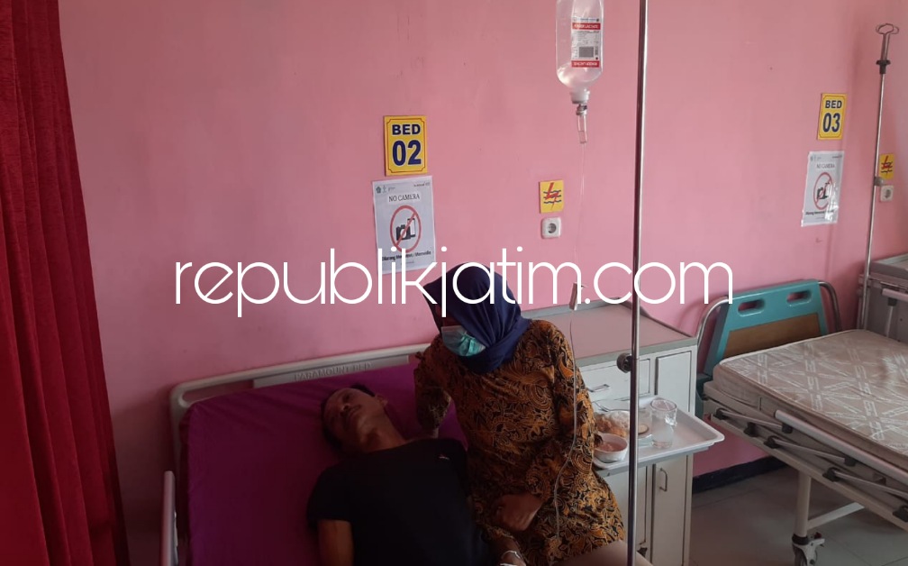 DIRAWAT - Ny Herni Isnaingsih menunggui suaminya, Muchtar Jumali yang menjadi korban penganiayaan di Desa/Kecamatan Tarik saat dirawat di Puskesmas Tarik, Rabu (14/06/2023). 