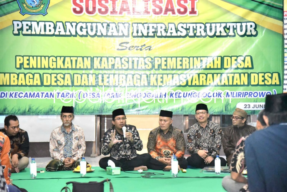 SOSIALISASI - Bupati Sidoarjo, Ahmad Muhdlor Ali mensosialisasikan rencana pembangunan jalan beton di Balai Desa Singogalih, Kecamatan Tarik, Sidoarjo, Jumat (23/06/2023) malam.