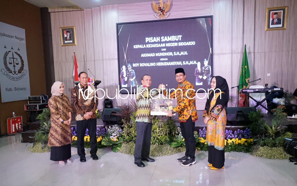 SERAHKAN - Bupati Sidoarjo Ahmad Muhdlor Ali menyerahkan cindera mata kepada Kepala Kejari Sidoarjo, Akhmad Muhdor yang digantikan Roy Revalino Herudiansyah saat pisah sambut di Aula Kejari Sidoarjo, Rabu (09/08/2023) malam.