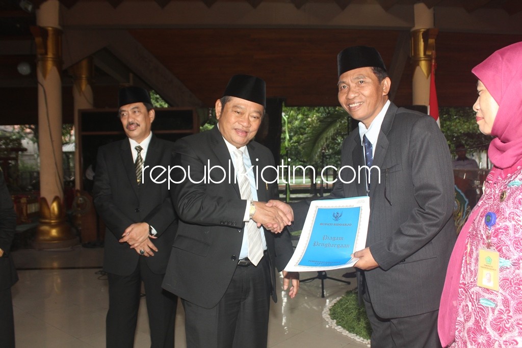 TALI ASIH - Bupati Sidoarjo, Saiful Ilah menyerahkan tali asih sebagai tanda terima kasih kepada mantan Sekda, Joko Sartono dan ratusan PNS lain yang memasuki masa pensiun, Kamis (01/02/2018).