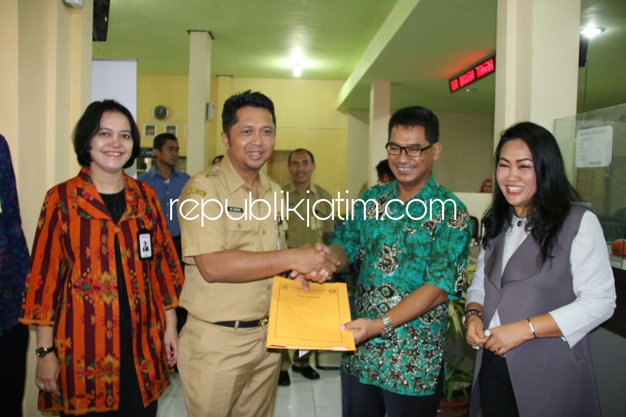 LAUNCHING - Kepala DPMPTSP Pemkab Sidoarjo, Ari Suryono bersama Kepala Cabang Bank Jatim, Hariyani mulai memberlakukan pembayaran IMB non tunai atau non cash, Senin (26/03/2018).